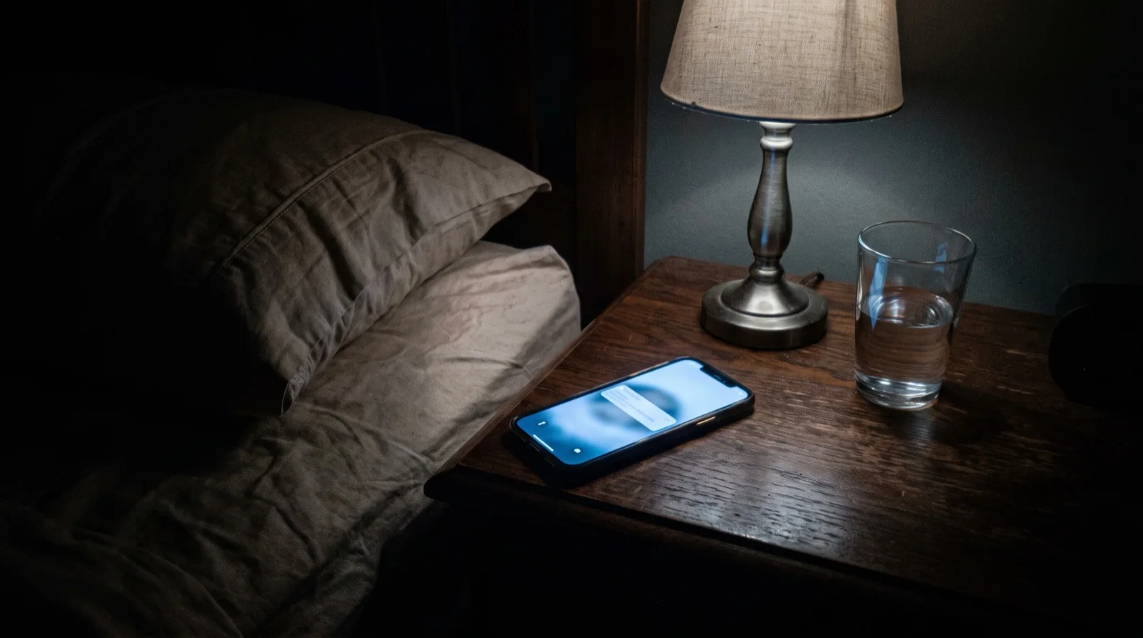 Smartphone acceso su un comodino di notte con una notifica sullo schermo